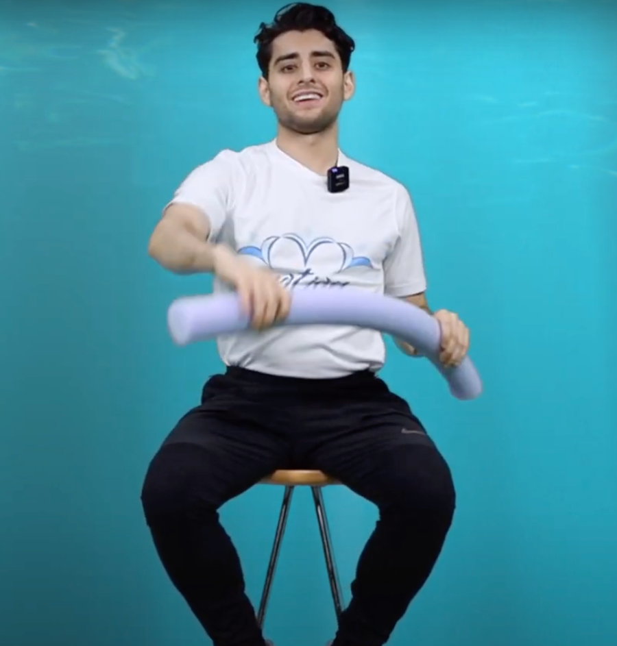 Man exercising with pool noodle on a chair